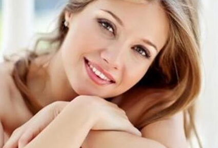 Picture of a trim woman sitting with arms crossed, and happy with her perfect Labiaplasty she had at Top Plastic Surgeons in beautiful San Jose, Costa Rica.  The woman has long sandy blonde hair and is facing the camera with head slightly tilted.
